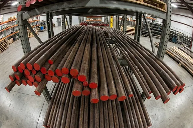 Heavy bronze bar stock in an industrial storage area